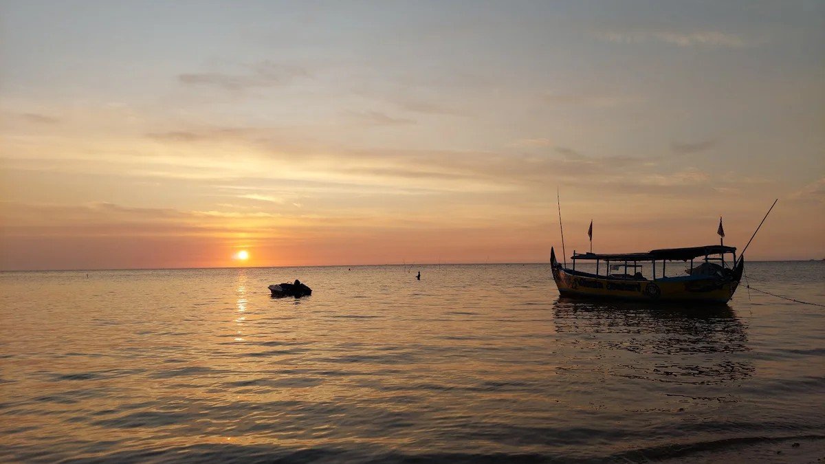 Suasana Pantai Blebak Jepara saat sunrise dengan pasir dan ombak tenang