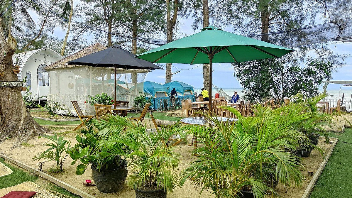 Pantai Lamaru Balikpapan dengan pasir putih dan area glamping tepi pantai saat pagi hari