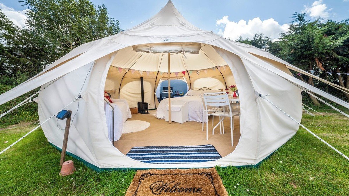 Pemandangan 7 tempat glamping Sukabumi dengan fasilitas lengkap, tenda dan vila di tengah alam hijau perbukitan