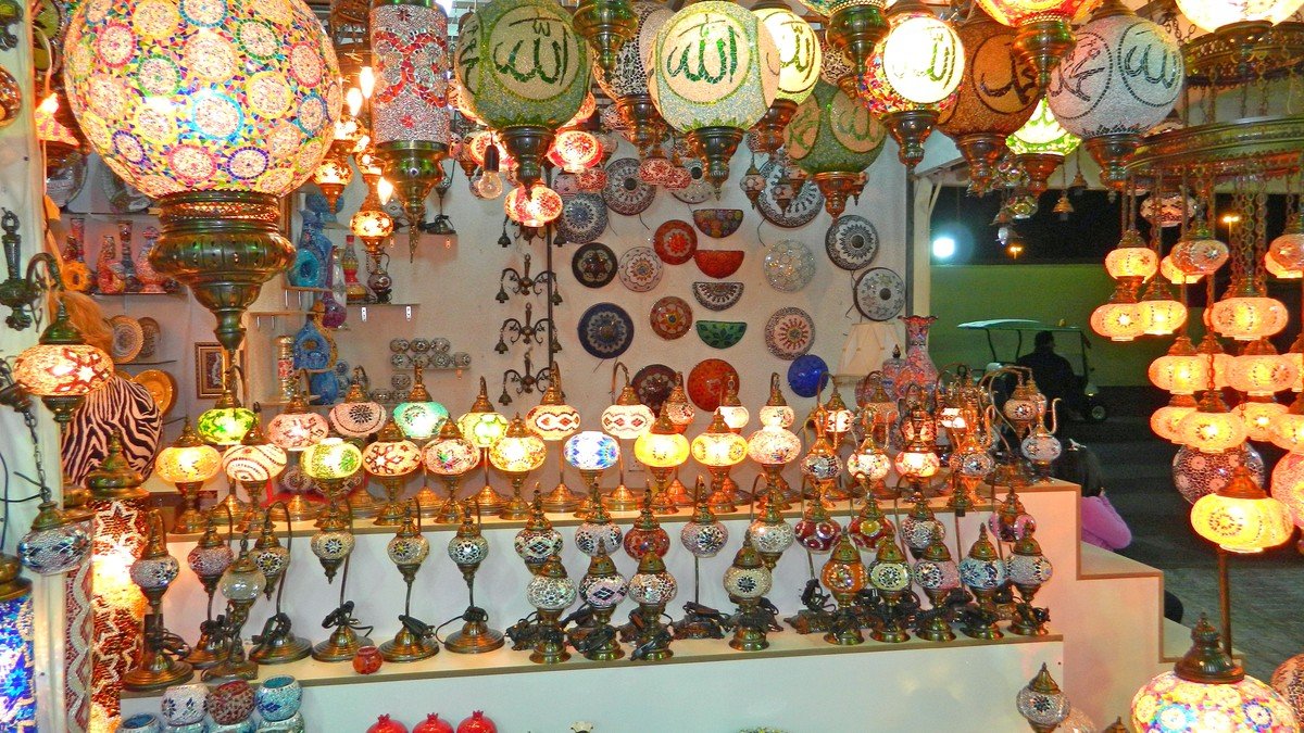 Lampu mozaik Turki menyala dengan pantulan warna-warni merah biru dan jingga di toko kerajinan Istanbul