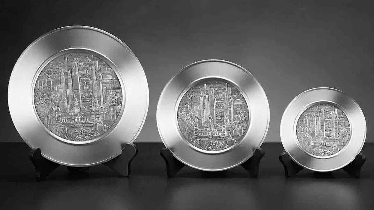 Kerajinan pewter Malaysia berupa gelas dan gantungan kunci dengan ukiran motif tradisional