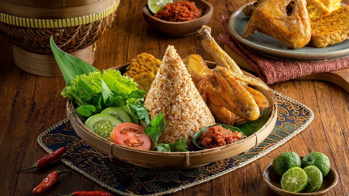 Ini 9 Makanan Khas Tasikmalaya yang Wajib Dicoba — nasi tutug oncom disajikan dengan lalapan dan sambal hijau di atas piring sederhana