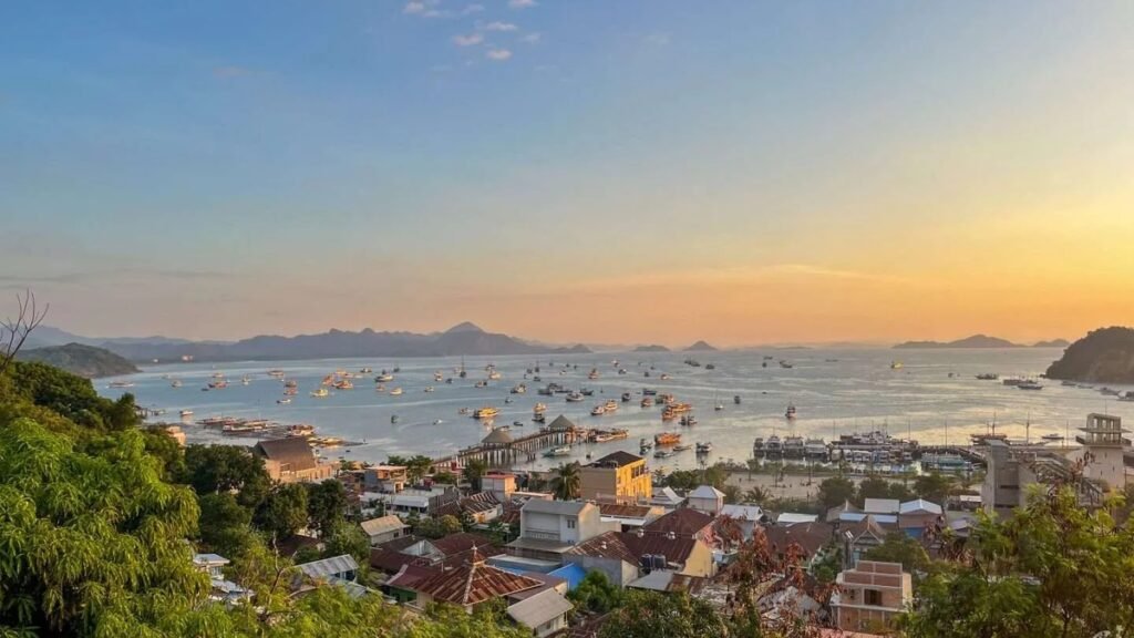 Pemandangan Labuan Bajo dari hotel di bukit dengan kapal-kapal phinisi berlabuh di pelabuhan
