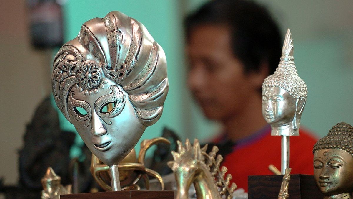Pengrajin perak Kotagede sedang mengukir perhiasan dengan alat tradisional di bengkel kecil