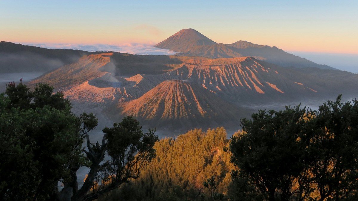 Traveler menikmati paket wisata Bromo 4 hari 3 malam di kawasan savana dengan latar gunung