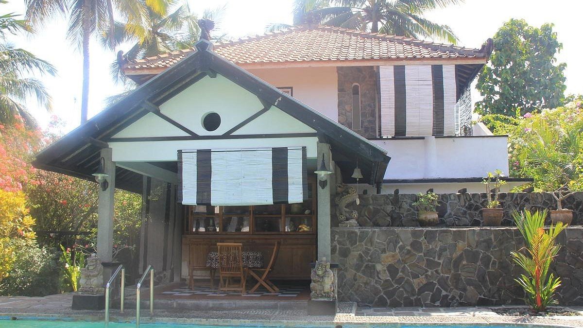 Adams Homestay Pangandaran dengan taman tropis rimbun dan kolam renang